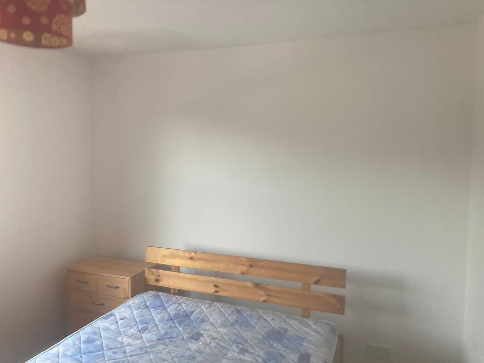 After: the same bedroom wall painted white